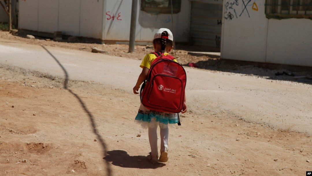 A girl walks to school in the Zaatari Refugee Camp for Syrian refugees, in northern Jordan, Aug. 6, 2017. 