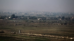 FILE - This photo taken Nov. 12, 2018, from Al Qaim in Iraq's border Anbar province shows the Syrian border city of Albukamal.