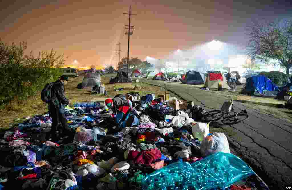 Evacuees sift through a pile of clothing at an encampment in a Walmart parking lot in Chico, California, Nov. 17, 2018. More than 1,000 people remain listed as missing in the worst-ever wildfire to hit the U.S. state.