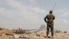 FILE - A Syrian soldier, with a tank in the background, is seen in the al-Qadam area near the Yarmouk Palestinian refugee camp in Damascus, Syria, April 29, 2018.