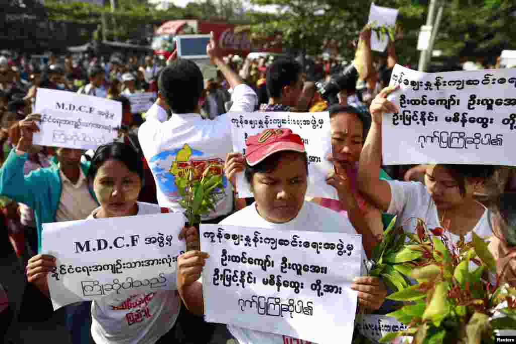 Family members hold signs as they wait for political prisoners to be released from Insein prison in Rangoon, Burma, Dec. 31, 2013. 