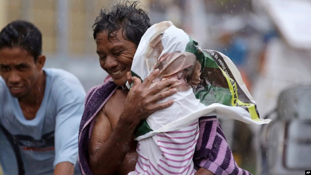 Residents of the slum community of Baseco evacuate to safer grounds at the onslaught of Typhoon Rammasun in Manila, Philippines, July 16, 2014.