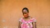 FILE - A woman checks her phone in Yaounde, Cameroon, April 23, 2020. An International Crisis Group report has found hate speech spread through social media to be a major contributor to ethnic and political tensions in the country. 