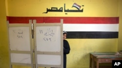 A woman prepares to vote during the second day of the presidential election at a polling station in Cairo, March 27, 2018. Egyptians are voting for a second day in a lackluster election that President Abdel-Fattah el-Sissi is virtually certain to win.