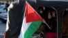 Una persona sostiene una bandera palestina mientras la gente celebra cerca del cruce fronterizo de Masnaa, después de que los rebeldes sirios anunciaran que habían derrocado al presidente Bashar al-Assad, Líbano, el 8 de diciembre de 2024.