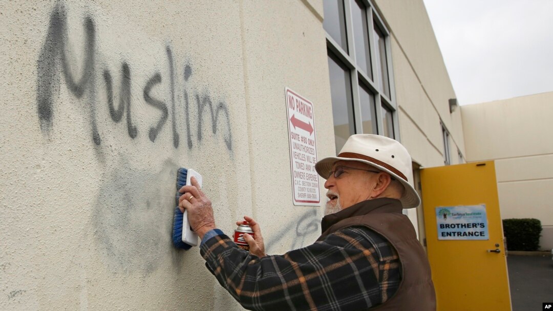 Tom Garing, un jubilado voluntario limpia un grafitti pintado en la pared de una mezquita en Roseville, California.