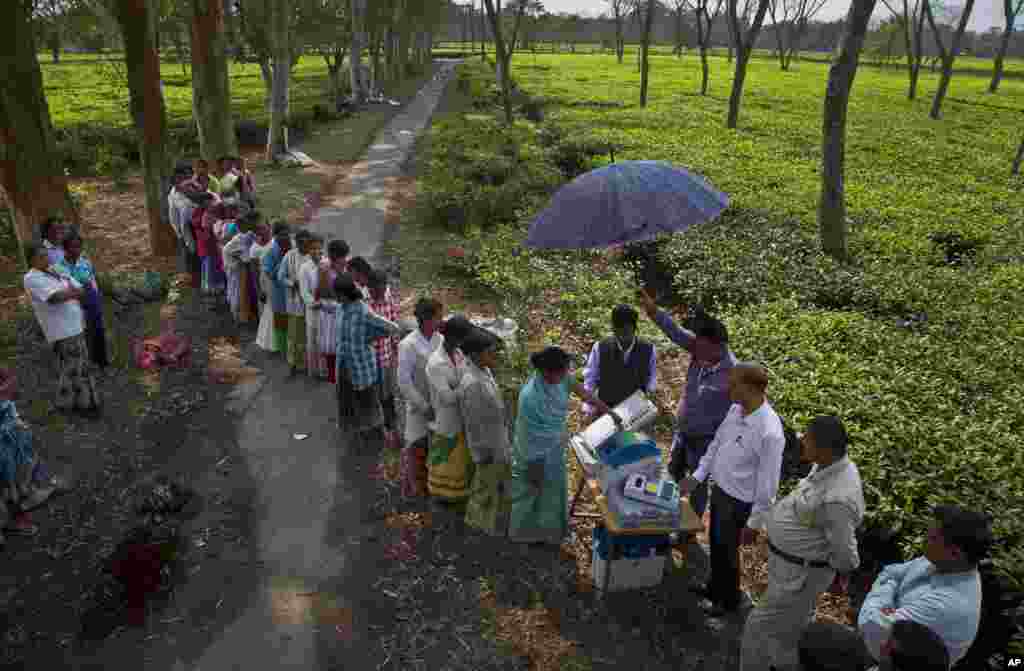 A woman casts her vote on the demo electronic voting machines and checks on Voter Verifiable Paper Audit Trail or VVPAT during an election awareness drive by district administration ahead of India's general election in Jorhat.
