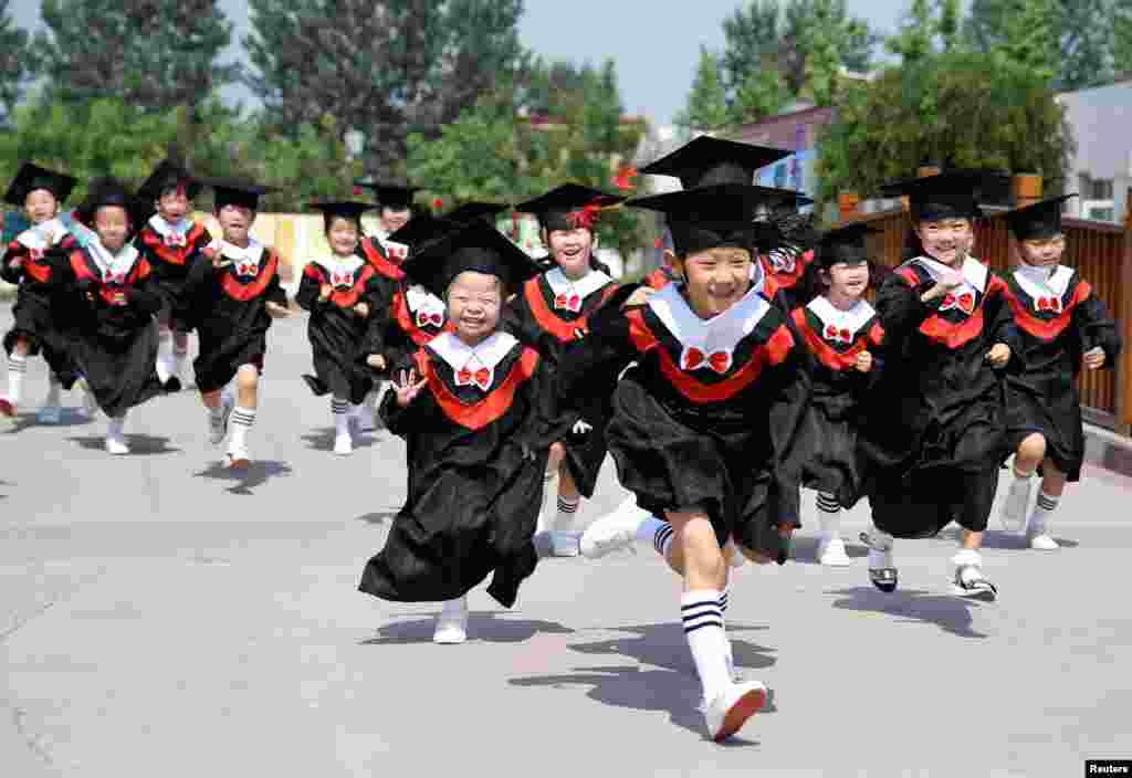 河北邯郸一所幼儿园的小朋友们穿学袍参加毕业典礼(2017年6月20日)