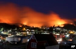 A wildfire approaches Chile's Dichato community, Jan. 30, 2017, where firefighters are working to keep the flames away from the estimated 800 homes.
