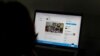 FILE - A woman looks at the Twitter page of pop star Rihanna in New Delhi, India, July 15, 2021.