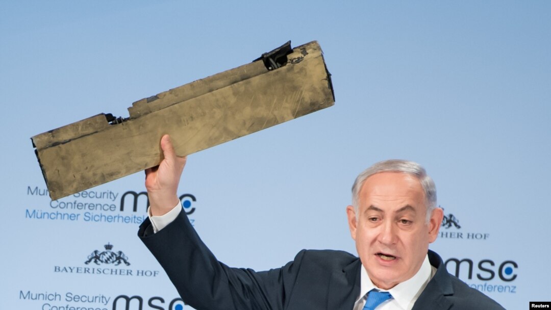 Israeli Prime Minister Benjamin Netanyahu holds up a remnant of what he said was a piece of Iranian drone which was shot down in Israeli airspace during his speech at the Munich Security Conference, Germany, Feb. 18, 2018. 