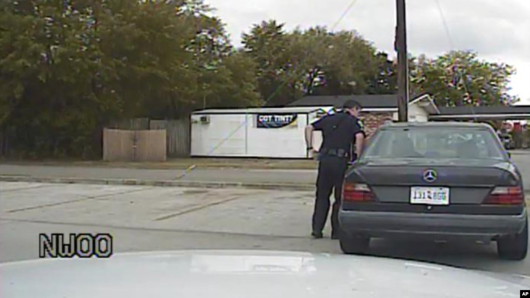 In this April 4, 2015, frame from dashboard video provided by the North Charleston Police Department, Patrolman Michael Thomas Slager stands by Walter Lamer Scott's car during a traffic stop in North Charleston, S.C. 