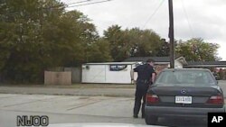 In this April 4, 2015, frame from dashboard video provided by the North Charleston Police Department, Patrolman Michael Thomas Slager stands by Walter Lamer Scott's car during a traffic stop in North Charleston, S.C. 
