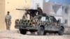 FILE - A member of Libyan forces allied with the U.N.-backed government fires a weapon on a pickup truck during a battle with Islamic State militants in Giza Bahreya, in Sirte, Libya, Oct. 27, 2016. 