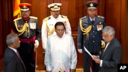 Ranil Wickremesinghe, right, takes oath as Sri Lanka’s prime minister in front Sri Lanka’s president Maithripala Sirisena, center, in Colombo, Sri Lanka, Friday, Aug. 21, 2015.