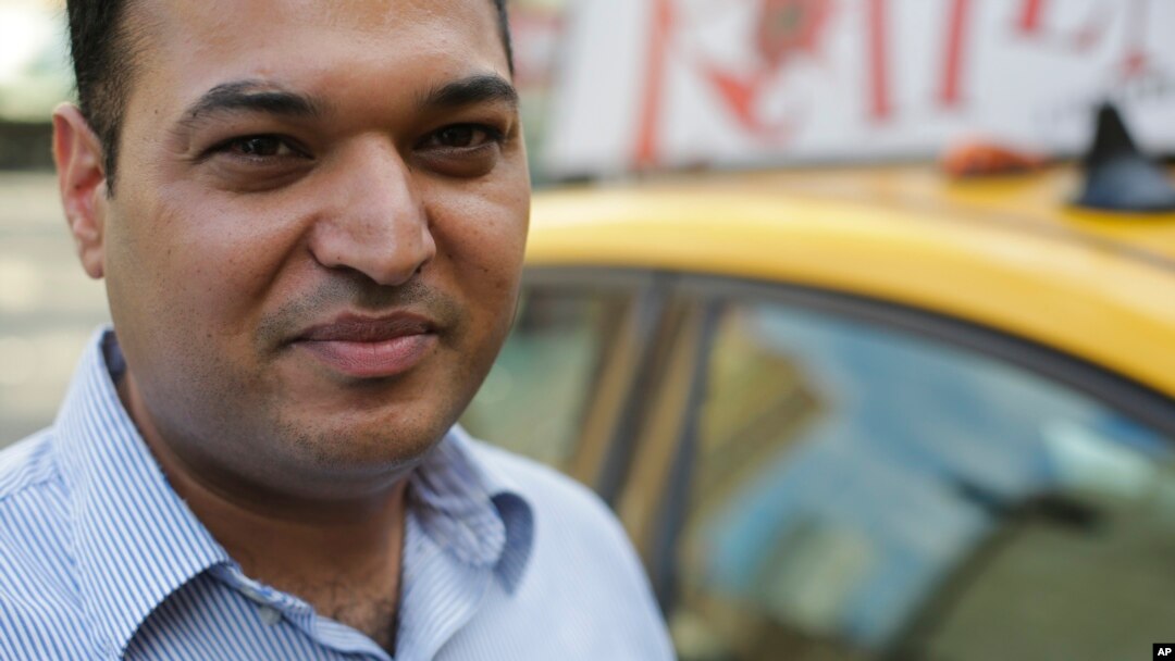 In this July 21, 2015 photo, yellow cab driver Jatinder Singh poses for a portrait near his taxi in New York. 