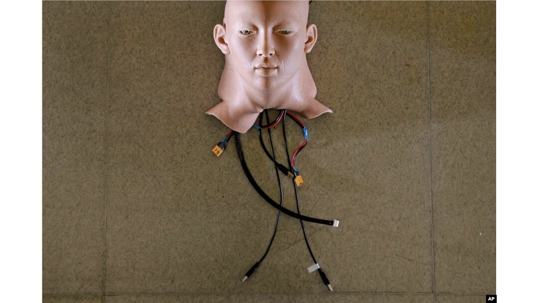 In this Sept. 28, 2017, photo, a robot head is covered by Hanson Robotics' skin, in Hong Kong.