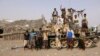 FILE - Tribal fighters loyal to the Yemeni government stand by a tank in al-Faza area near Hodeida, Yemen, June 1, 2018.