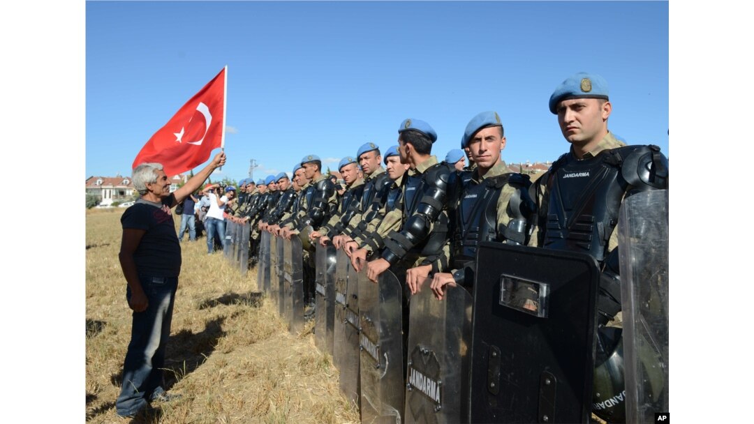 A protester argues at a paramilitary police barricade as security block thousands of people outside the Silivri jail complex in Silivri, Turkey, Aug. 5, 2013.