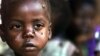 A starving child is covered with flies at the pediatric malnutrition ward at the Lilongwe Central Hospital, Malawi, April 24, 2002.