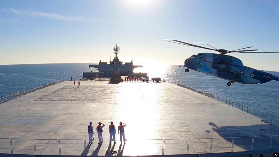 Esta imagen tomada de un video publicado el miércoles 13 de enero de 2021 por el ejército iraní muestra un helicóptero aterrizando en el buque logístico Makran durante un simulacro de la marina. [Foto del ejército iraní vía AP]