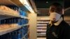 FILE - An employee of Chandarana Foodplus supermarket in Adlife Plaza takes items off the shelf to fill out an online shopping order in Nairobi, Kenya, May 05, 2020.