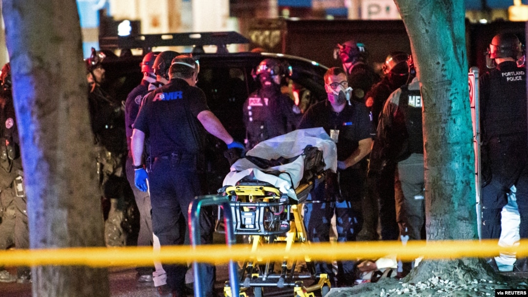 Police help remove the the body of a man who was shot dead amid weekend street clashes between supporters of President Donald Trump and counter-demonstrators in Portland, Oregon, Aug. 29, 2020.