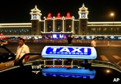FILE - A taxi waits near the Beijing Railway Station.