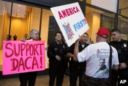 FILE - A supporter of President Donald Trump challenges police officers and a Deferred Action for Childhood Arrivals (DACA) program advocate during a rally outside the office of California Democratic Sen. Dianne Feinstein in Los Angeles.