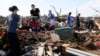 Volunteers retrieve clothing and other household items at a home destroyed by a tornado, across the street from the Plaza Towers elementary school in Moore, Oklahoma, May 22, 2013. 