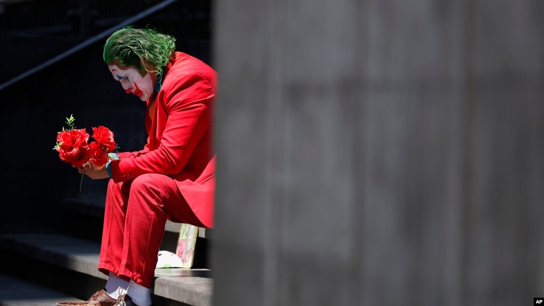 David Vázquez, un artista callejero disfrazado de Joker, espera con la esperanza de que lleguen los peatones que pagarán por tomarse fotos con él en la Ciudad de México, el lunes 23 de marzo de 2020. 