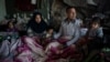 FILE - A family from Afghanistan gather at an abandoned building in Edirne, near the Turkish-Greek border, March 6, 2020. 