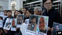 FILE - Pro-democracy activists hold pictures of Chinese activist Wu Gan (2nd-R) and other activists outside the Chinese central government's liaison office in Hong Kong, Dec. 27, 2017. 