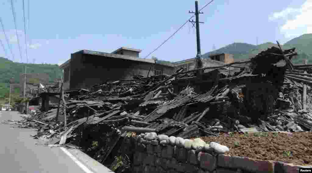 Collapsed houses are seen after an earthquake of 6.6 magnitude, on the side of a road leading from Ya'an city to Luzhou county, in Ya'an, Sichuan province, Apr. 20, 2013.