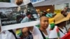 A minority Kachin holds up an image showing Kachin refugees in northern Burma during a protest in front of Burmese Embassy in Bangkok, Thailand, January 11, 2013. 