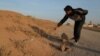 A resident points to what he believes is a land mine in the village of al-Heesha in Raqqa district of Syria after it was captured from Islamic State, Nov. 15, 2016.