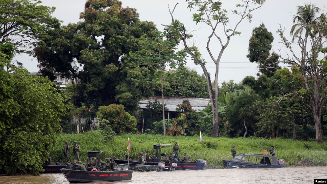 Soldados venezolanos patrullan por el río Arauca, la frontera entre Colombia y Venezuela, visto desde Arauquita, Colombia, el 28 de marzo de 2021.