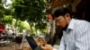 FILE - Vietnamese activist Anh Chi searches the internet at Tu Do (Freedom) cafe in Hanoi, Aug. 25, 2017. Amnesty International has found that a hacking group known as Ocean Lotus has been staging more spyware attacks on Vietnamese human rights activists.