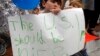 Shua Rich, age 6, holds his sign as he protests with his mother during a rally against U.S. immigration policies outside an office for Rep. Kevin Yoder, June 22, 2018, in Overland Park, Kan.