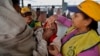 A medical volunteer administers polio immunization drops to a child at a railway station in Allahabad, India, Jan. 13, 2014. 
