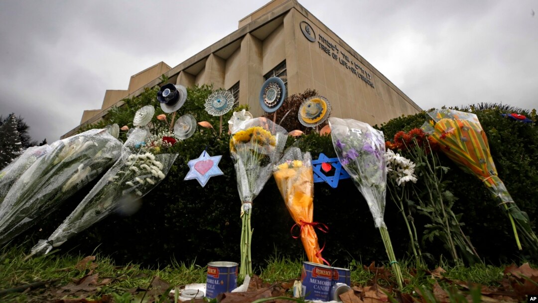 A makeshift memorial of flowers rests on bushes outside the Tree of Life synagogue in Pittsburgh, Nov. 20, 2018. On Thanksgiving, some Americans will celebrate new friendships forged in the wake of tragedy. 