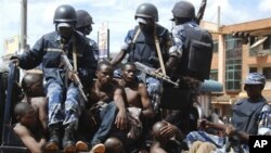 Rioters sit on the back of a police truck after their arrest in the capital city Kampala, Uganda after riots broke out on April 29, 2011