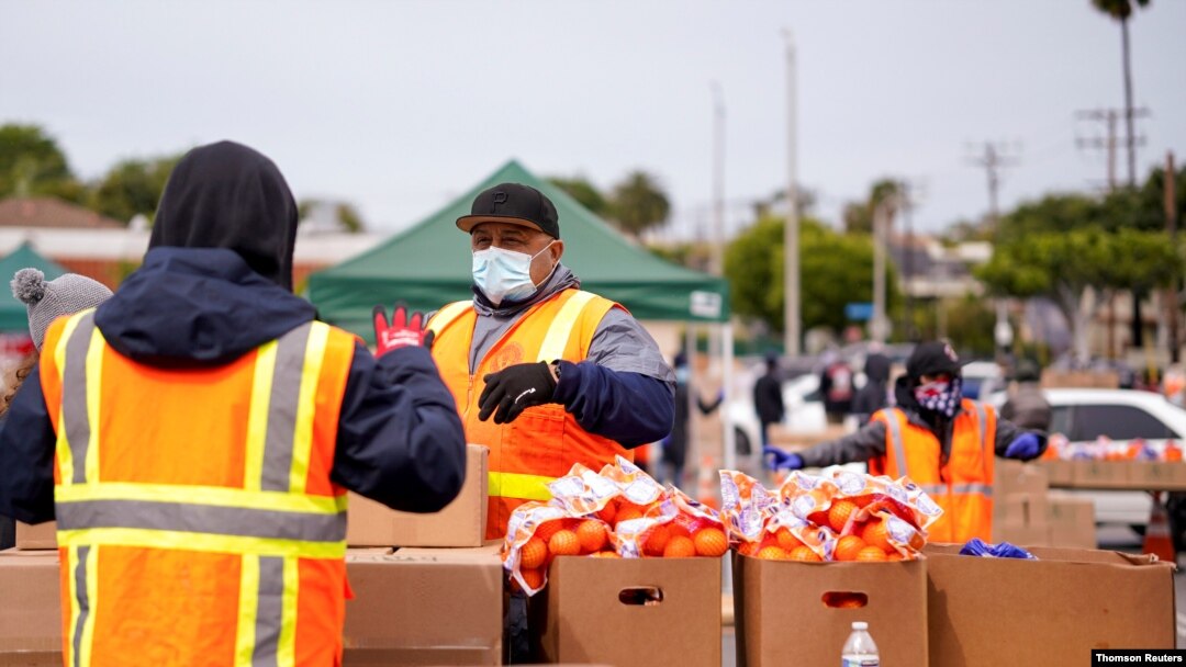 Voluntarios en Los Ángeles entregan comida a personas sin trabajo debido al impacto de la pandemia.