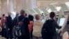 FILE - Passengers arriving from abroad at Los Angeles International Airport use new automated passport kiosks.