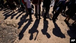 ARCHIVO - Migrantes esperan ser procesados ​​por la Oficina de Aduanas y Patrulla Fronteriza de Estados Unidos después de cruzar el Río Grande e ingresar a Estados Unidos desde México, el 19 de octubre de 2023, en Eagle Pass, Texas.