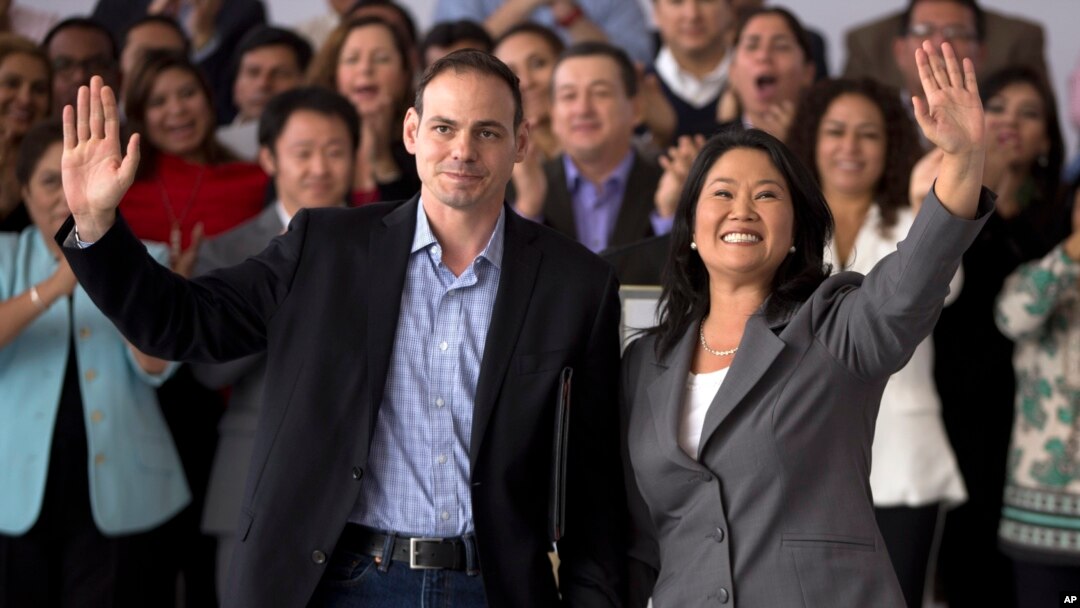 Keiko Fujimori saluda a la prensa después de aceptar la derrota en las elecciones presidenciales acompañada de su esposo Mark Villanella, en Lima, Perú, el 10 de junio de 2016.
