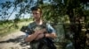 FILE - A Ukrainian soldier is seen guarding a position at the frontline near Avdiivka, Donetsk region, eastern Ukraine, July 19, 2015.
