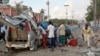 Somali policeman runs through wreckage outside the Sahafi Hotel, Mogadishu, Nov. 1, 2015.