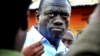 FILE - Ugandan opposition leader Kizza Besigye speaks to journalists, May 19, 2011, outside his house shortly after returning home after a confrontation with police, in Kasangati, Uganda. 