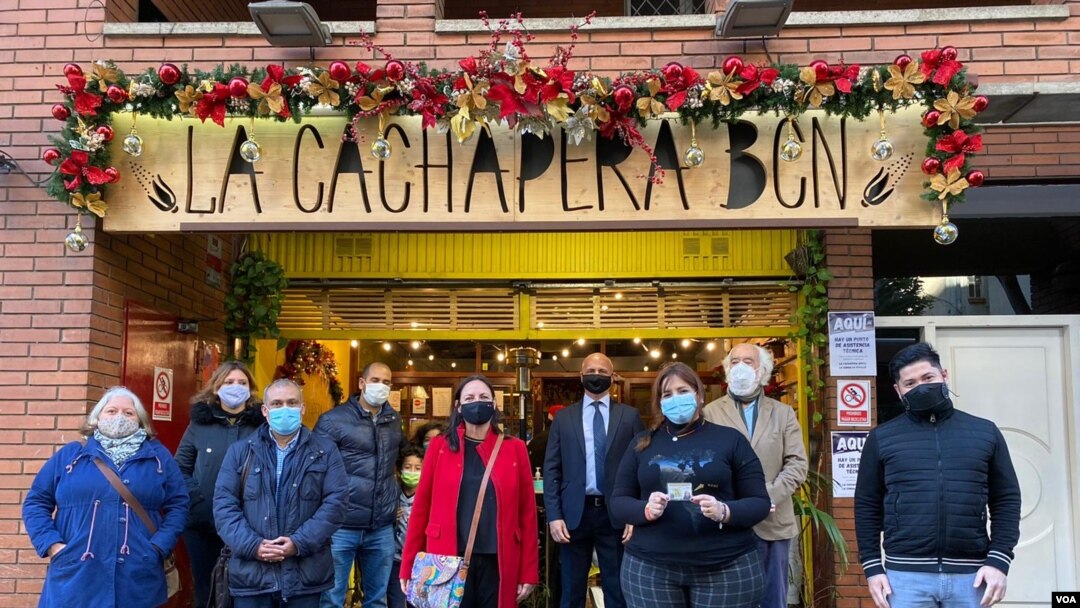 Voluntarios y observadores internacionales frente al restaurante La Cachapera Bcn, uno de los puntos de asistencia técnica durante la jornada de votación de la consulta popular en Barcelona, España, el 12 de diciembre de 2020. [Foto VOA/Júlia Riera]..